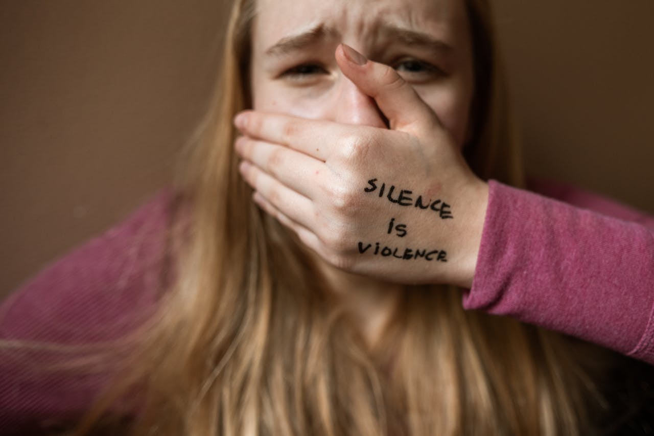 Woman in Purple Shirt Covering Her Face With Her Hand